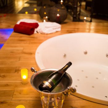 bougies et bouteilles de champagne à côté du jacuzzi